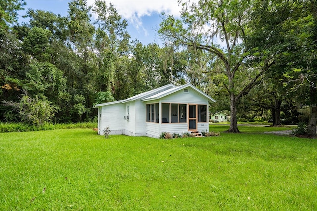 exterior space with a lawn and a sunroom