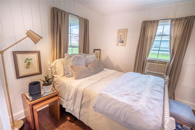 bedroom featuring wood-type flooring, cooling unit, and wooden walls