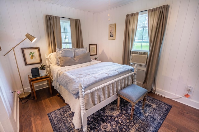 bedroom featuring hardwood / wood-style flooring, cooling unit, and wood walls