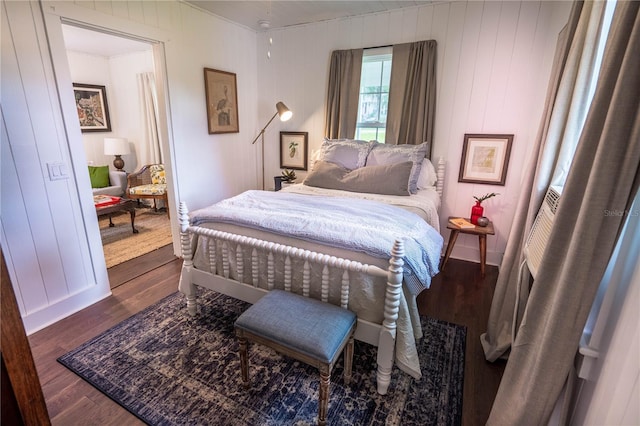 bedroom featuring wood walls and dark hardwood / wood-style flooring