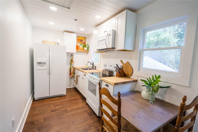 kitchen featuring dark hardwood / wood-style flooring, white appliances, sink, white cabinetry, and butcher block counters