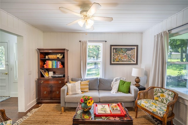 living room with ceiling fan, hardwood / wood-style floors, wood ceiling, and wooden walls