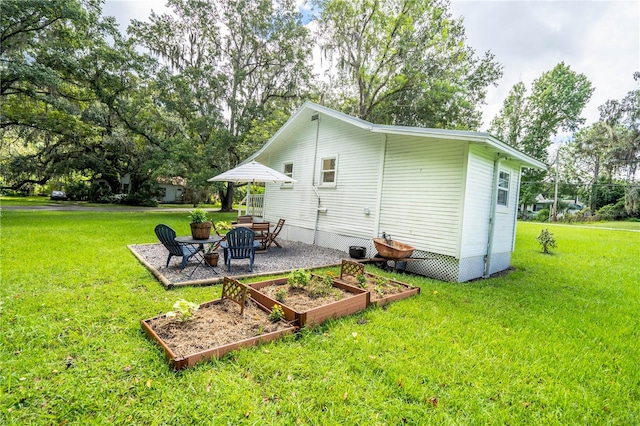 rear view of property featuring a lawn and a patio