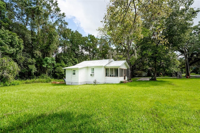 back of house with a lawn and a sunroom