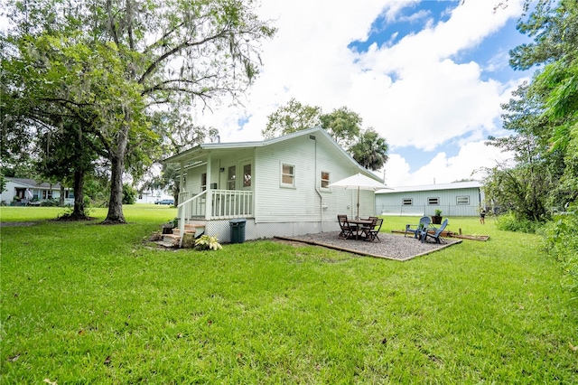 back of house with a patio area and a yard