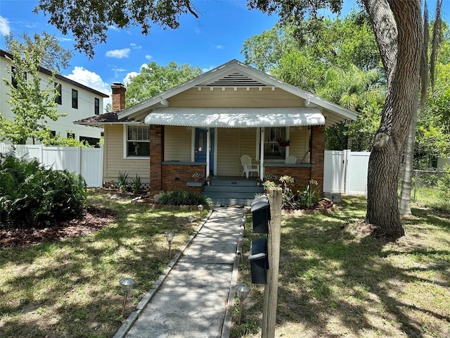 bungalow-style house with covered porch and a front lawn