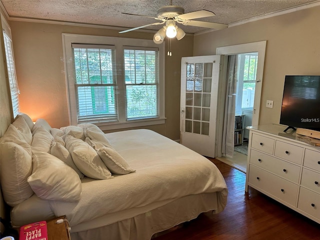 bedroom featuring ceiling fan, multiple windows, dark hardwood / wood-style flooring, and ornamental molding