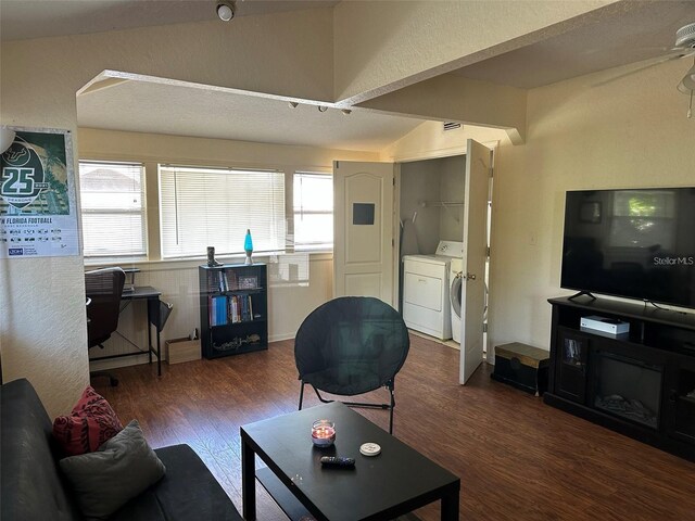 living room with a textured ceiling, dark hardwood / wood-style floors, ceiling fan, and washer and dryer