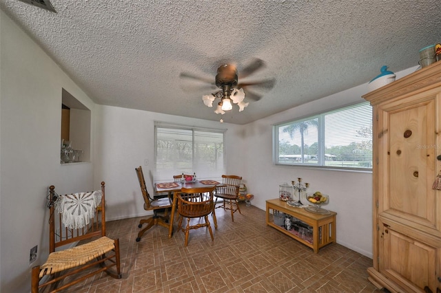 dining area with a textured ceiling and ceiling fan