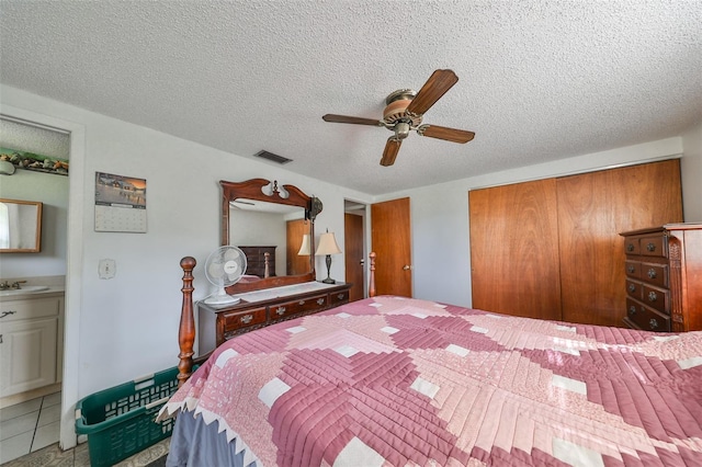 bedroom with a textured ceiling, ceiling fan, and ensuite bathroom