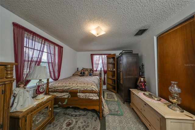 bedroom featuring multiple windows and a textured ceiling