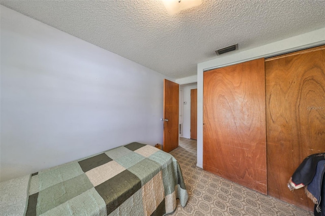 bedroom featuring a textured ceiling and a closet