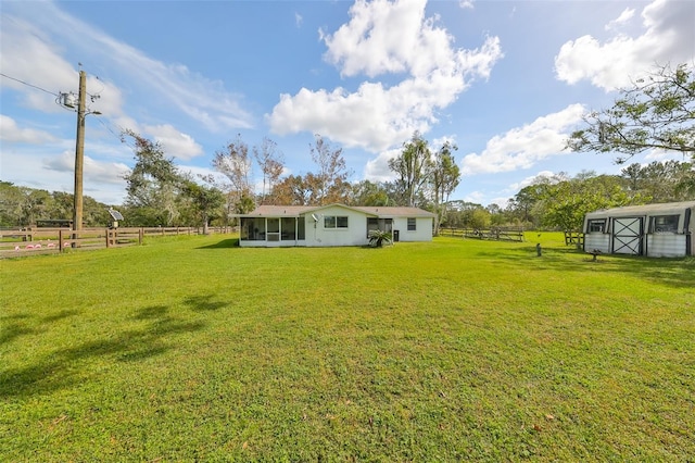 view of yard with a rural view and a sunroom