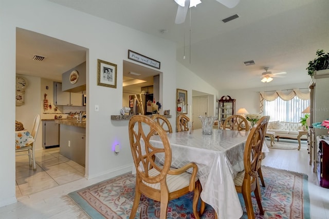 dining space with light wood-type flooring, vaulted ceiling, and ceiling fan