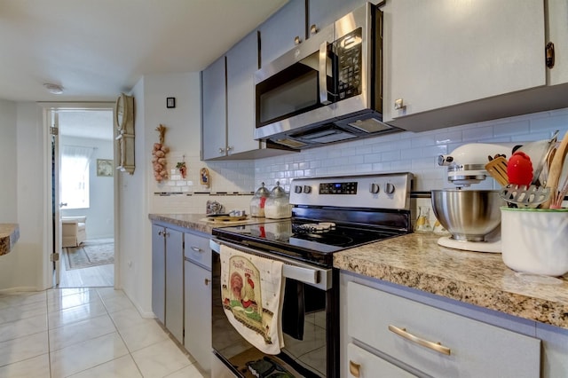 kitchen featuring decorative backsplash, gray cabinetry, stainless steel appliances, and light tile patterned floors