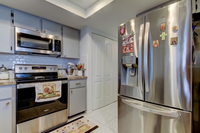 kitchen featuring tasteful backsplash, stainless steel appliances, and light tile patterned floors