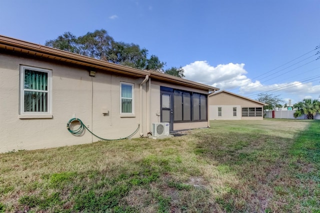 back of property featuring ac unit and a lawn