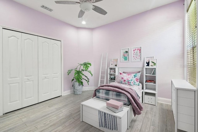 bedroom featuring light wood-type flooring, ceiling fan, and a closet