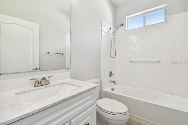 full bathroom with vanity, tiled shower / bath combo, and toilet