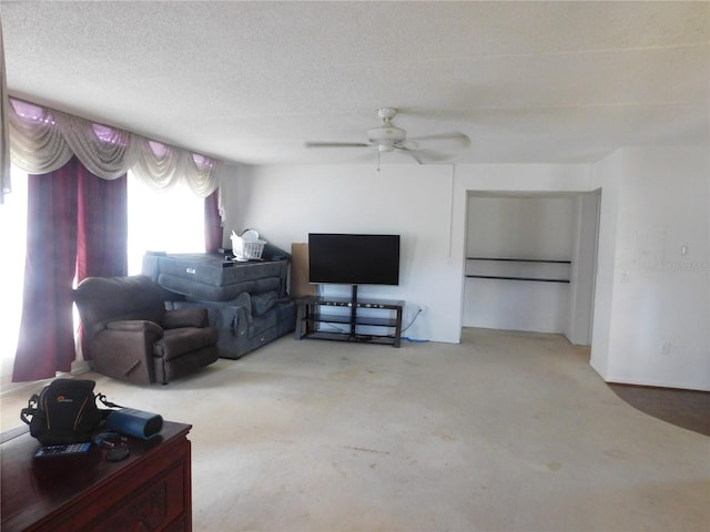 carpeted living room with ceiling fan and a textured ceiling