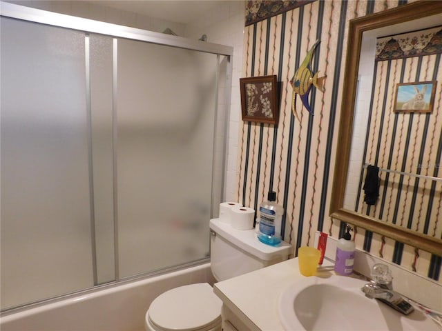 full bathroom with vanity, combined bath / shower with glass door, and toilet