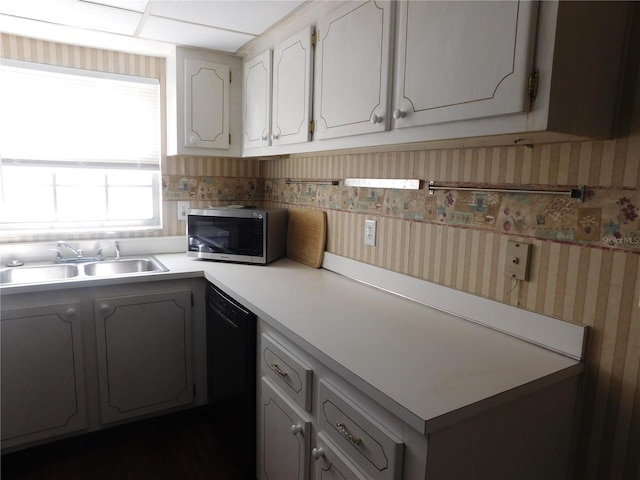 kitchen with white cabinets, black dishwasher, and sink