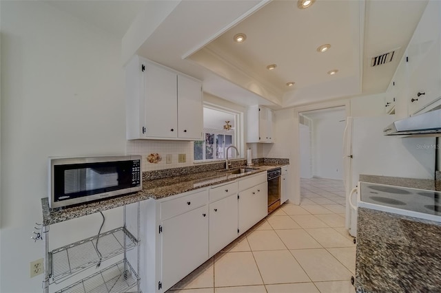 kitchen featuring light tile patterned flooring, black dishwasher, sink, white cabinets, and dark stone countertops