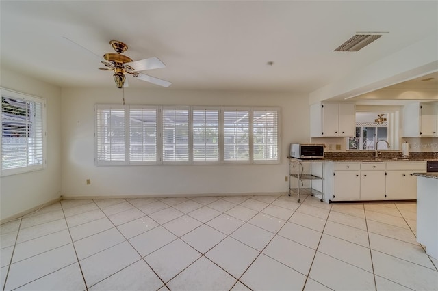 kitchen featuring white cabinets, a healthy amount of sunlight, and ceiling fan