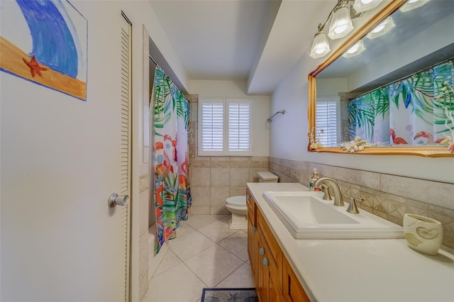 bathroom featuring vanity, tile patterned flooring, toilet, and tile walls