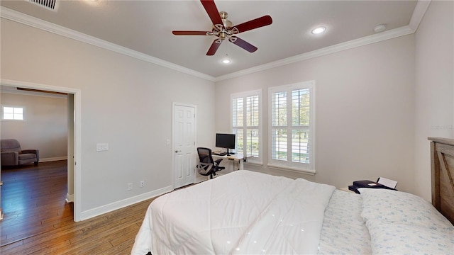 bedroom with multiple windows, hardwood / wood-style flooring, ceiling fan, and crown molding