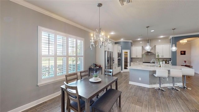 dining area with ornamental molding, dark hardwood / wood-style flooring, and a healthy amount of sunlight