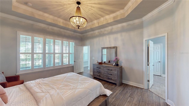 bedroom with ornamental molding, a chandelier, hardwood / wood-style flooring, and a raised ceiling