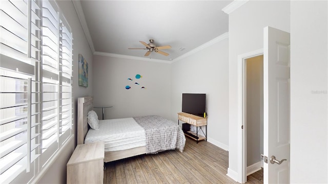 bedroom with ornamental molding, hardwood / wood-style flooring, and ceiling fan