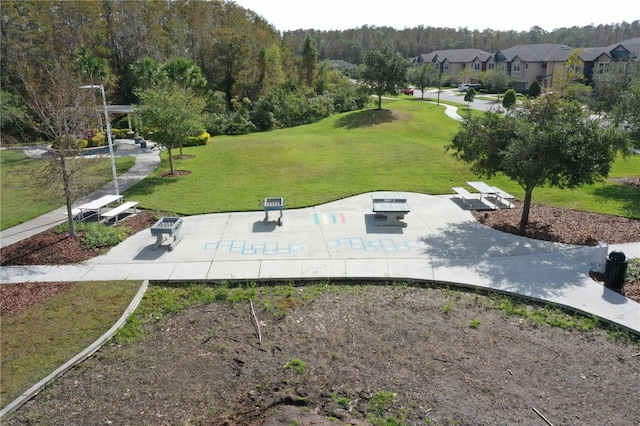 surrounding community with a patio and a yard