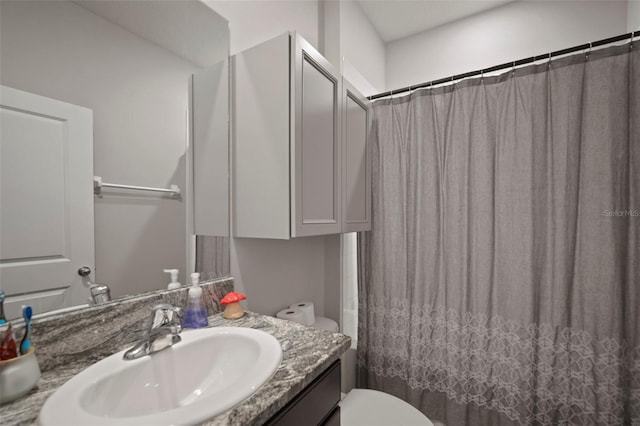 bathroom featuring toilet, vanity, and walk in shower