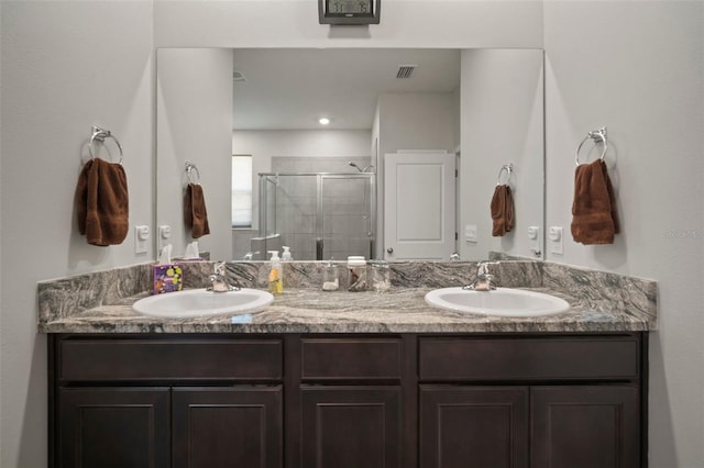 bathroom with a shower with shower door and vanity