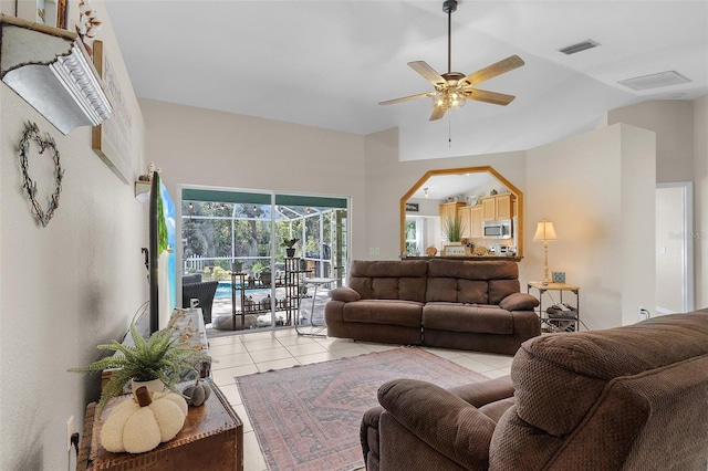 living room with ceiling fan, light tile patterned floors, and a high ceiling