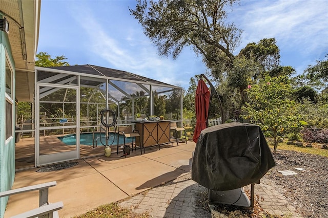 view of patio with area for grilling, a lanai, and a bar