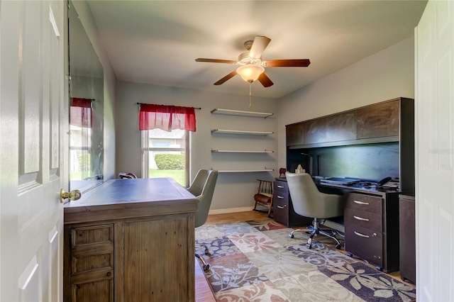 office with light hardwood / wood-style flooring and ceiling fan