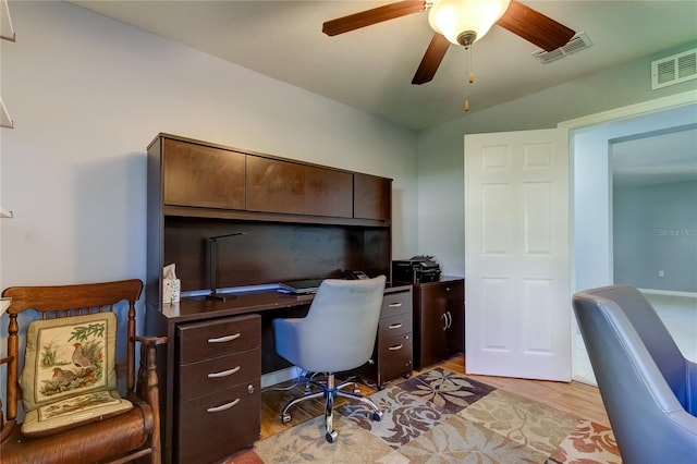 home office with ceiling fan, light hardwood / wood-style flooring, and vaulted ceiling