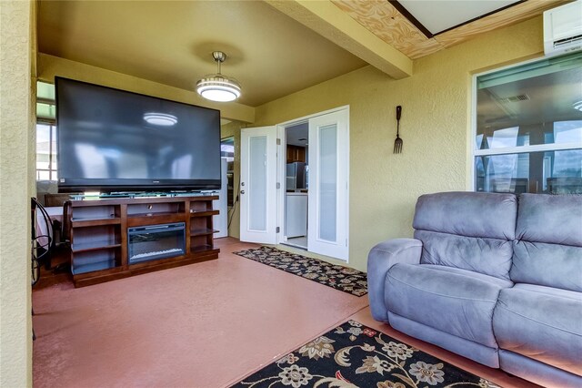 living room with beamed ceiling and a wall unit AC