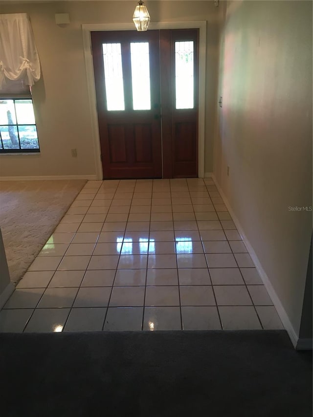 foyer entrance featuring light tile patterned flooring and plenty of natural light