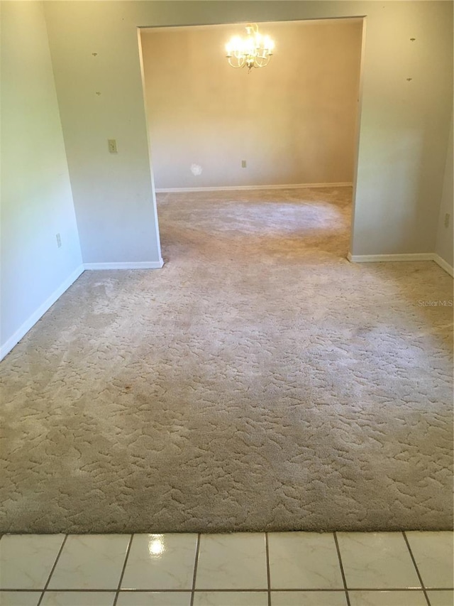 unfurnished room featuring carpet flooring and a notable chandelier