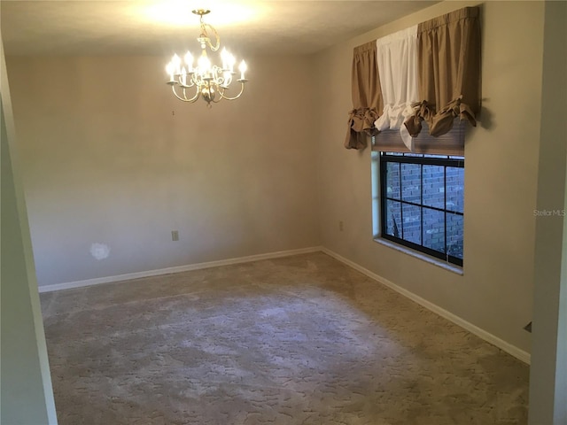 empty room with carpet floors and a notable chandelier