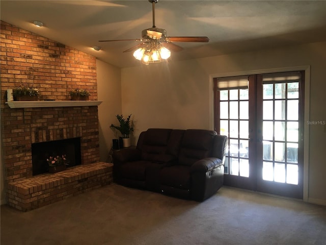 carpeted living room with ceiling fan, lofted ceiling, a fireplace, and french doors