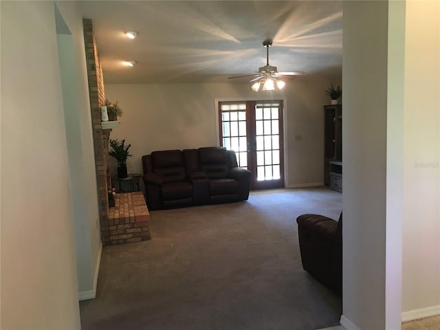 living room with carpet, a fireplace, ceiling fan, and french doors