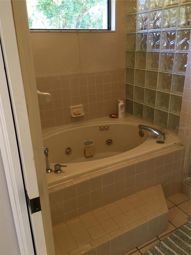 bathroom featuring a relaxing tiled tub and tile patterned flooring