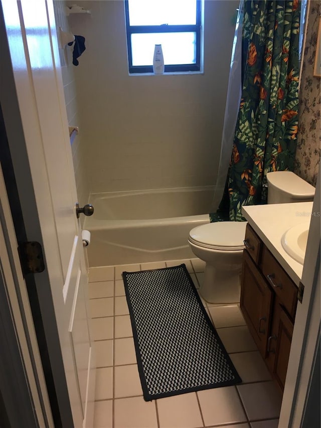 full bathroom featuring tile patterned flooring, vanity, toilet, and shower / bath combo with shower curtain