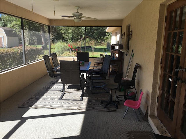 sunroom featuring ceiling fan and plenty of natural light