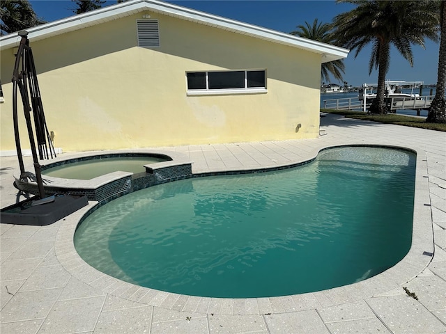 view of pool featuring a pool with connected hot tub and a patio